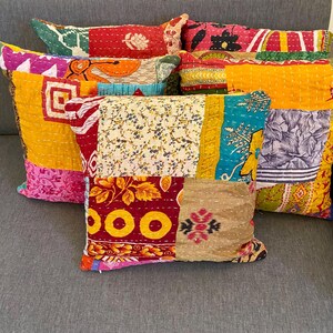 May include: A collection of colorful patchwork throw pillows. Each pillow features a unique design with various patterns, including floral, geometric, and abstract motifs. The pillows are made of different fabrics and colors, creating a vibrant and eclectic look.