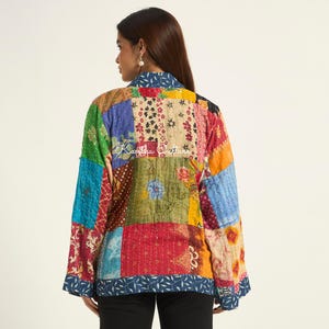 Puede incluir: Una chaqueta de manga larga con un dise&ntilde;o de patchwork que presenta varios patrones florales y geom&eacute;tricos en colores vibrantes, incluyendo rojo, amarillo, azul y verde. La prenda tiene cuello y costuras visibles. El texto Kantha Culture es visible.