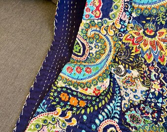 May include: A navy blue paisley patterned quilt with a colorful floral design. The quilt features a detailed stitch pattern and a dark blue border. The design includes shades of blue, green, orange, and red.