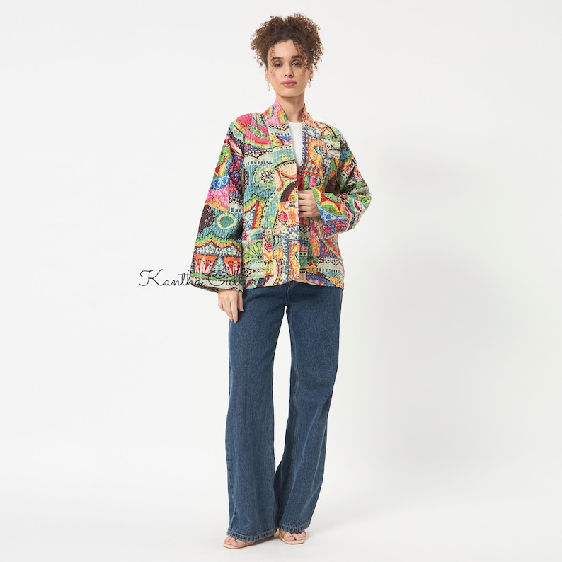 Pu&ograve; includere: Una giacca a maniche lunghe aperta sul davanti con un vivace motivo patchwork multicolore e dettagli di cucitura intricati. Il capo &egrave; abbinato a jeans in denim blu scuro a gamba larga. Il testo Kantha Quilt &egrave; visibile sul lato sinistro.
