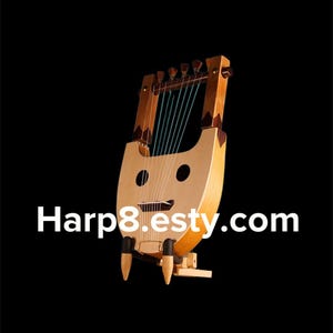 Puede incluir: Una lira de madera con siete cuerdas y un diseño de cara sonriente. El instrumento tiene un cuerpo marrón claro con un mástil y clavijero marrón más oscuro. Las cuerdas son de color verde azulado y el fondo es negro.