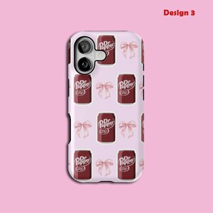 May include: A phone case featuring a repeating pattern of Dr. Pepper cans and pink bows on a pale pink backdrop. The Dr. Pepper cans are dark red with white text and the number 23. The words "Design 3" are in the upper right corner.