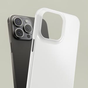 May include: A black smartphone with a triple-lens camera is positioned behind a clear, white phone case. The case is made of a glossy material and has a cutout for the camera. The phone and case are set against a neutral background.