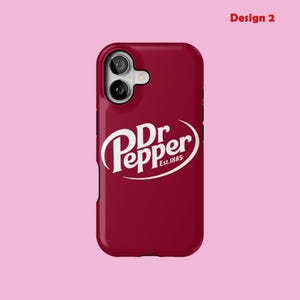 May include: A burgundy phone case with the Dr Pepper logo in white, and the text "Est.1885" below. The case has a glossy finish and a camera cutout at the top. The words "Design 2" are in the top right corner.