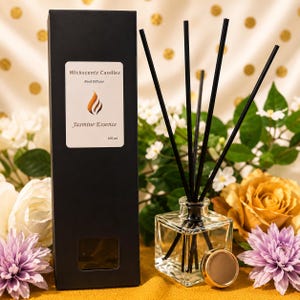 May include: A black rectangular box labeled Wickscentz Candlez Reed Diffuser Jasmine Essence 100 ml next to a clear square glass bottle containing liquid and four black reed sticks with a gold-toned cap resting beside the bottle base.