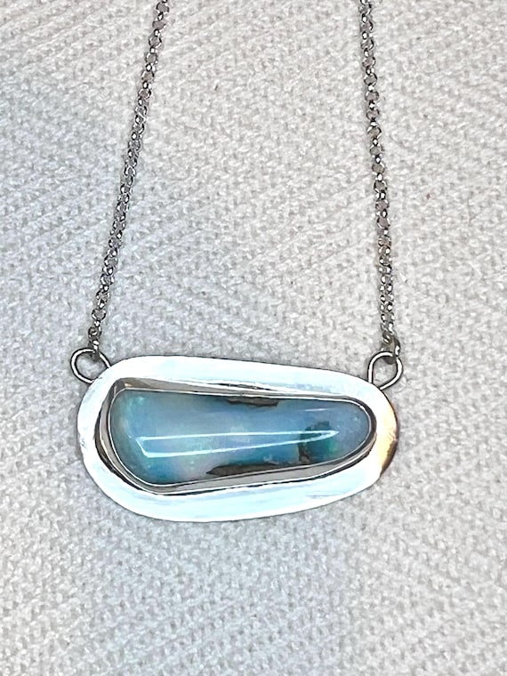 Silver framed blue opal pendant