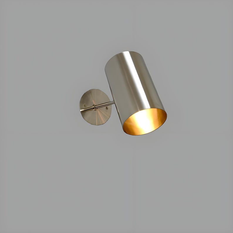 Bring timeless elegance to your interior with this handcrafted Mid-Century Brass Wall Sconce. Inspired by 1950s design, it features clean lines, a satin nickel finish, and soft ambient lighting—perfect for bedrooms, hallways, or reading nooks. Made from solid brass and built to last, this sconce blends vintage charm with modern craftsmanship. Hardwired with E12/E14 socket. Bulb not included.