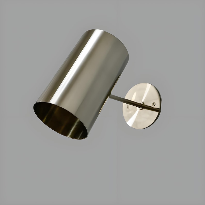 Bring timeless elegance to your interior with this handcrafted Mid-Century Brass Wall Sconce. Inspired by 1950s design, it features clean lines, a satin nickel finish, and soft ambient lighting—perfect for bedrooms, hallways, or reading nooks. Made from solid brass and built to last, this sconce blends vintage charm with modern craftsmanship. Hardwired with E12/E14 socket. Bulb not included.