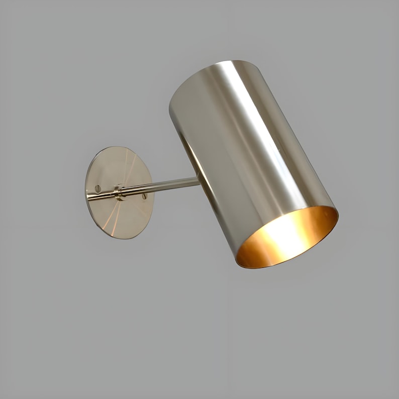 Bring timeless elegance to your interior with this handcrafted Mid-Century Brass Wall Sconce. Inspired by 1950s design, it features clean lines, a satin nickel finish, and soft ambient lighting—perfect for bedrooms, hallways, or reading nooks. Made from solid brass and built to last, this sconce blends vintage charm with modern craftsmanship. Hardwired with E12/E14 socket. Bulb not included.