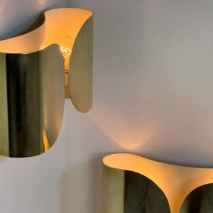 Inspired by iconic mid-century Italian design, the Foglio Wall Sconce brings refined elegance and architectural presence to any interior. Crafted from solid brass with a luxurious Italian gold finish, this sculptural sconce evokes the graceful fold of paper—its name, Foglio, meaning “sheet” in Italian.