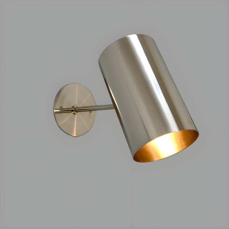 Bring timeless elegance to your interior with this handcrafted Mid-Century Brass Wall Sconce. Inspired by 1950s design, it features clean lines, a satin nickel finish, and soft ambient lighting—perfect for bedrooms, hallways, or reading nooks. Made from solid brass and built to last, this sconce blends vintage charm with modern craftsmanship. Hardwired with E12/E14 socket. Bulb not included.