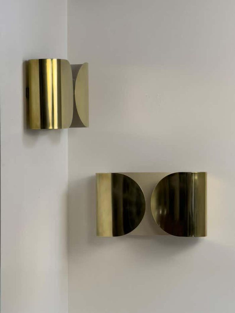 Inspired by iconic mid-century Italian design, the Foglio Wall Sconce brings refined elegance and architectural presence to any interior. Crafted from solid brass with a luxurious Italian gold finish, this sculptural sconce evokes the graceful fold of paper—its name, Foglio, meaning “sheet” in Italian.
