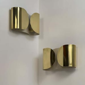 Inspired by iconic mid-century Italian design, the Foglio Wall Sconce brings refined elegance and architectural presence to any interior. Crafted from solid brass with a luxurious Italian gold finish, this sculptural sconce evokes the graceful fold of paper—its name, Foglio, meaning “sheet” in Italian.