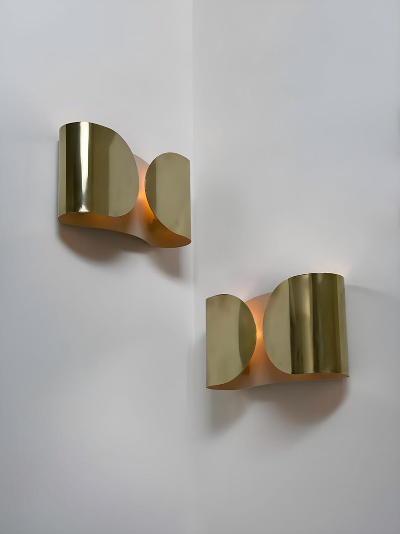 Inspired by iconic mid-century Italian design, the Foglio Wall Sconce brings refined elegance and architectural presence to any interior. Crafted from solid brass with a luxurious Italian gold finish, this sculptural sconce evokes the graceful fold of paper—its name, Foglio, meaning “sheet” in Italian.