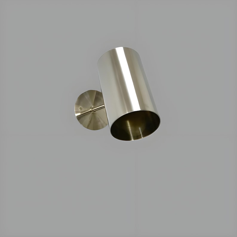 Bring timeless elegance to your interior with this handcrafted Mid-Century Brass Wall Sconce. Inspired by 1950s design, it features clean lines, a satin nickel finish, and soft ambient lighting—perfect for bedrooms, hallways, or reading nooks. Made from solid brass and built to last, this sconce blends vintage charm with modern craftsmanship. Hardwired with E12/E14 socket. Bulb not included.