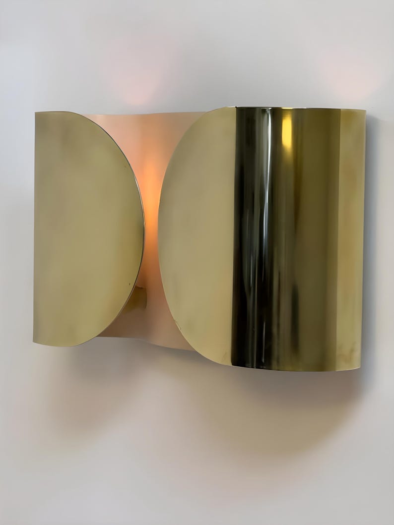 Inspired by iconic mid-century Italian design, the Foglio Wall Sconce brings refined elegance and architectural presence to any interior. Crafted from solid brass with a luxurious Italian gold finish, this sculptural sconce evokes the graceful fold of paper—its name, Foglio, meaning “sheet” in Italian.
