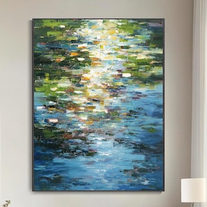 Puede incluir: Gran pintura al óleo abstracta que representa una escena acuática con tonos azules, verdes y amarillos. La obra de arte se exhibe en un salón moderno con paredes blancas, un gran sofá y sillas rojas. Las dimensiones de la pintura no son visibles.
