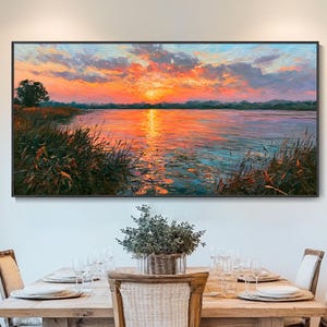 Può includere: Un dipinto paesaggistico rettangolare che raffigura un tramonto vibrante su un lago calmo, con nuvole arancioni e rosa che si riflettono sull'acqua. Canneti verde scuro e un singolo albero incorniciano la riva con pennellate materiche.