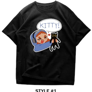 Könnte beinhalten: Schwarzes T-Shirt mit einer Cartoon-Illustration einer Person mit Kopfhörern, die eine schwarze Katze hält. Eine Sprechblase über der Person sagt "KITTY!". Der Text "STYLE #1" befindet sich am unteren Rand des T-Shirts.