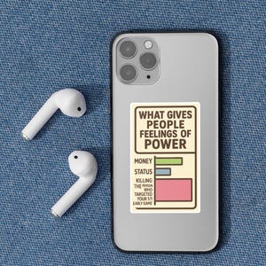 May include: A smartphone with a sticker that reads "WHAT GIVES PEOPLE FEELINGS OF POWER" with a bar graph. White wireless earbuds are next to the phone on a blue denim surface.