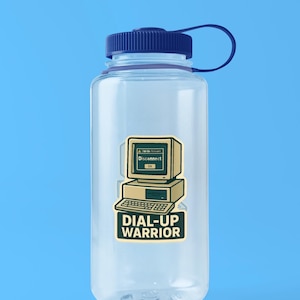 May include: A clear plastic water bottle with a dark blue screw-top lid and a loop handle. A sticker on the front features a beige vintage computer monitor displaying a Disconnect window above a keyboard and the text DIAL-UP WARRIOR.