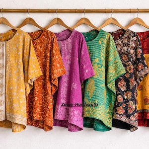 May include: A collection of six colorful, patterned tops hanging on wooden hangers. The tops feature various designs in shades of yellow, orange, pink, green, black, and red. The tops are made of a lightweight fabric.