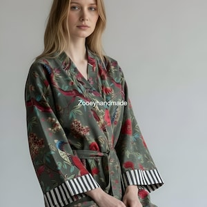May include: A green floral patterned robe with a belt, featuring red and blue birds and flowers. The robe has black and white striped cuffs and the text "Zooeyhandmade".