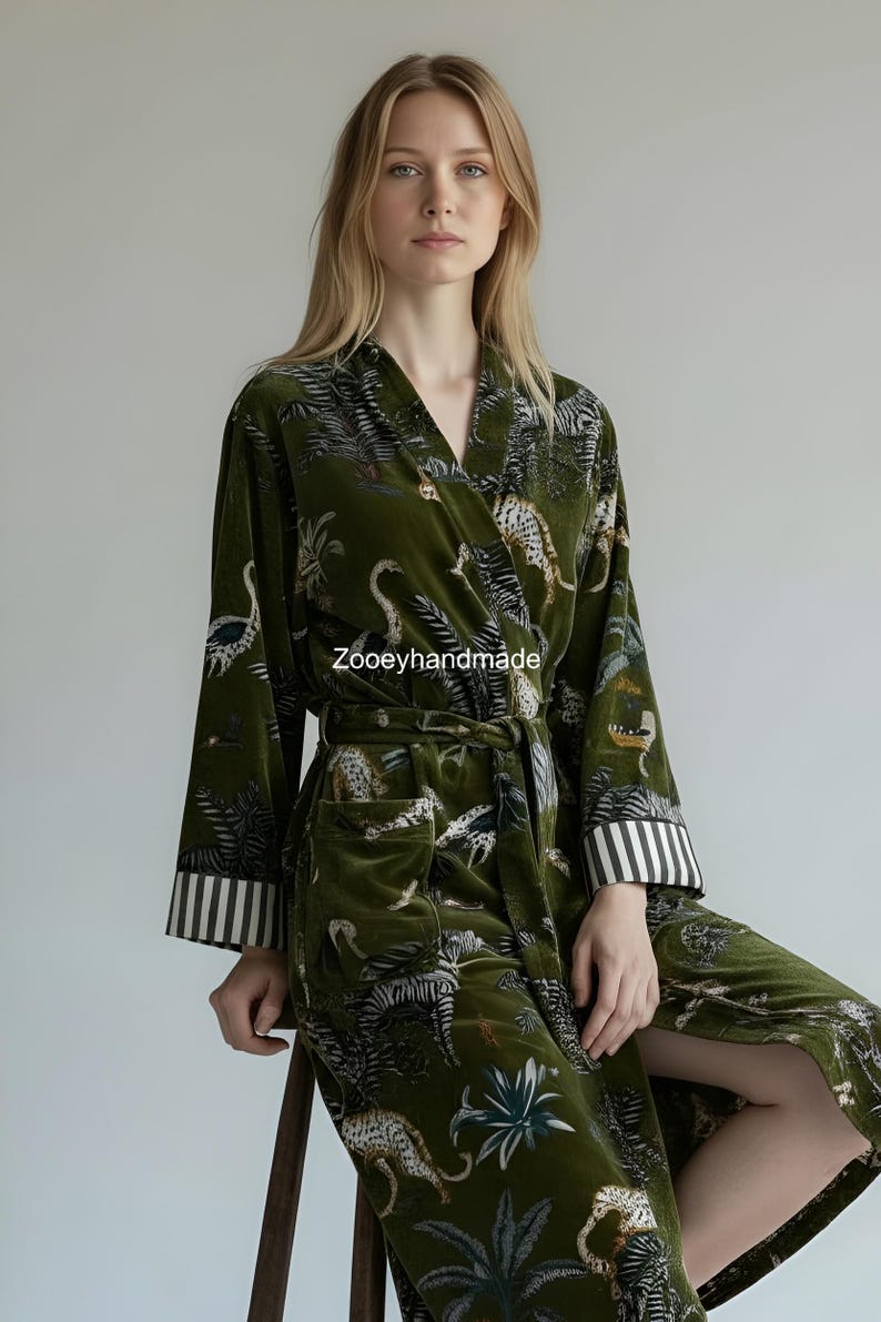 May include: Olive green velvet robe with a jungle animal print, including zebras and leopards. The robe has a V-neck, a matching belt, and striped cuffs. The text "Zooeyhandmade" is visible on the robe.