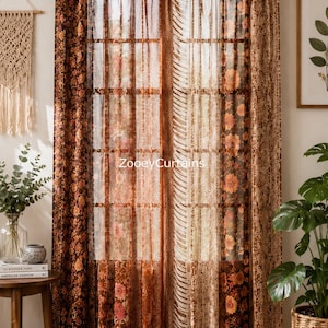 Può includere: Una coppia di tende a passanti con un design patchwork caratterizzato da vari motivi floreali e geometrici nei toni del marrone, arancione e crema. Il tessuto è semi-trasparente e lascia filtrare la luce. Il testo ZooeyCurtains è stampato al centro.