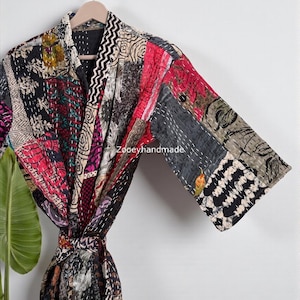 Könnte beinhalten: Ein Patchwork-Bademantel mit einer Vielzahl von Mustern und Farben, darunter Schwarz, Rot und Grau. Der Bademantel hängt an einem Holzbügel. Der Text "Zooeyhandmade" ist auf dem Bademantel zu sehen.