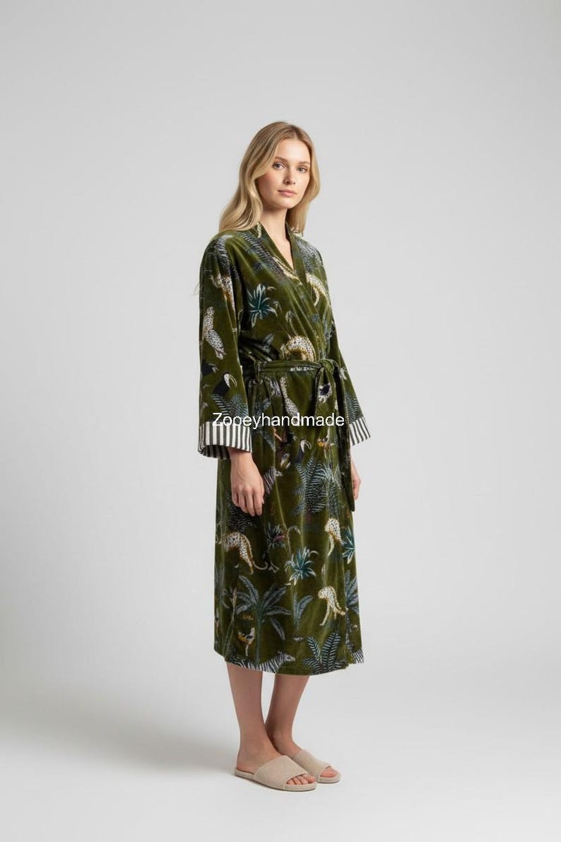 May include: Olive green velvet robe with a jungle and leopard print. The robe has a wrap-around design with a matching belt. The sleeves have a striped cuff. The text "Zooeyhandmade" is printed on the robe.