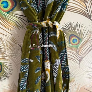 May include: Olive green velvet robe with a jungle print featuring white and yellow animal figures, blue and white leaves, and the text "Zooeyhandmade". The robe is tied with a matching belt.