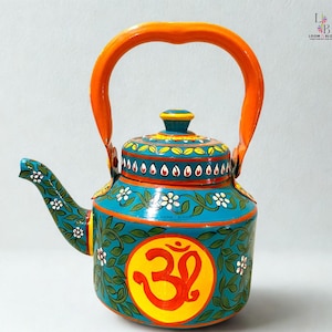 May include: Hand-painted teal teapot with orange handle and accents. The teapot features floral and leaf designs, white flowers, and a yellow circle with an orange Om symbol. The lid and spout are also decorated with intricate patterns.