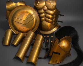 May include: A complete set of golden armor, including a breastplate, shield, helmet with a black plume, and arm and leg guards. The armor has a polished finish and is displayed on a gray surface. The shield features a distinctive V-shaped design.