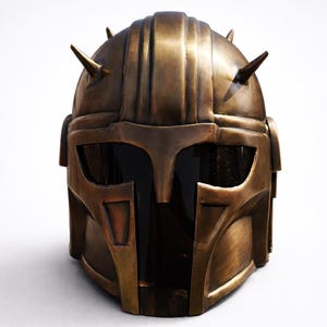 K&ouml;nnte beinhalten: Ein bronzefarbener Helm mit detailliertem Design, mit Visier und mehreren spitzen Stacheln. Der Helm hat ein verwittertes Aussehen, das auf eine kampferprobte &Auml;sthetik hindeutet. Das Gesamtdesign erinnert an einen Kriegerhelm.