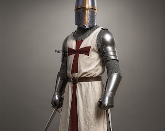 May include: A full suit of medieval armor, including a helmet, chainmail, and metal plating. The white tunic features a large red cross. A brown belt and a sword complete the ensemble. The armor is designed to protect the wearer.