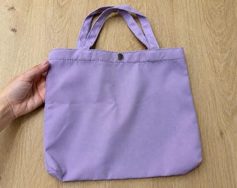 Kleine stoffen draagtas in lila of mosterdgeel met drukknoopsluiting.