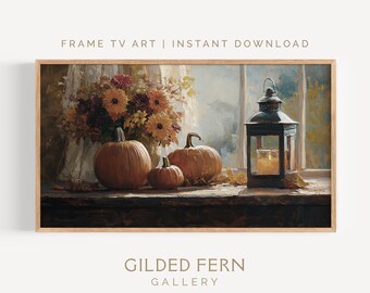May include: A framed digital art print featuring a still life with pumpkins, flowers, and a lantern. The artwork has a warm color palette with orange, brown, and yellow hues. The text "FRAME TV ART | INSTANT DOWNLOAD" and "GILDED FERN GALLERY" are visible.