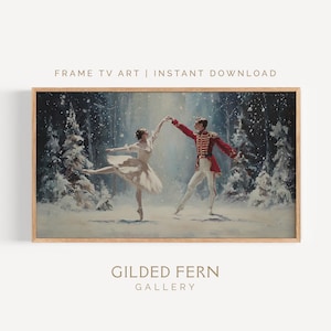 May include: A framed print of a winter ballet scene. A ballerina in a white dress and a man in a red coat dance in a snowy forest. The print is in a light wood frame. Text on the print reads "FRAME TV ART | INSTANT DOWNLOAD" and "GILDED FERN GALLERY".