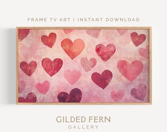 May include: A framed print featuring a pattern of hearts in various shades of pink and red against a textured background. The text "FRAME TV ART | INSTANT DOWNLOAD" and "GILDED FERN GALLERY" are visible.