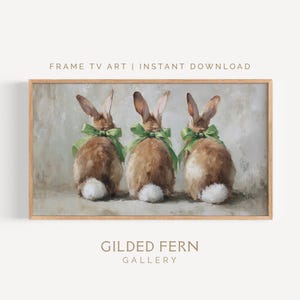 May include: A framed print featuring three brown rabbits with green bows, viewed from the back. The artwork has a textured, painterly style with the text "FRAME TV ART | INSTANT DOWNLOAD" and "GILDED FERN GALLERY".