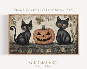 May include: A framed print featuring two black cats with orange eyes flanking a carved jack-o'-lantern. The artwork has a vintage style with fall leaves and the text "FRAME TV ART | INSTANT DOWNLOAD" and "GILDED FERN GALLERY".
