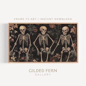 May include: Framed art print featuring three skeletons holding hands against a dark floral background. The artwork is in a wooden frame and includes the text "FRAME TV ART | INSTANT DOWNLOAD" and "GILDED FERN GALLERY".