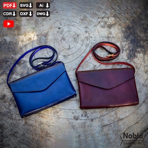 May include: Two leather crossbody bags. One is a deep blue, the other a rich burgundy. Both have a rectangular envelope design with a flap closure and a long, thin strap. The bags are displayed on a textured, wooden surface.