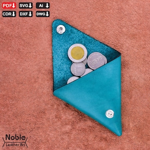 Puede incluir: Un monedero de cuero turquesa, de forma triangular, con cierre de botón a presión. El monedero está abierto, revelando varias monedas. El fondo es una superficie texturizada de color marrón rojizo. El texto "Noble Leather Art" está en la esquina inferior izquierda.