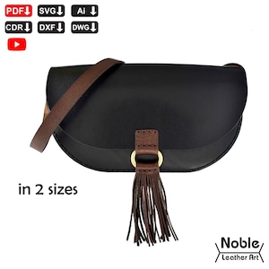 May include: Black leather saddlebag with a brown leather strap and tassel. The bag has a curved shape and a gold-colored ring detail. The text "in 2 sizes" is visible on the lower left. The bag is from Noble Leather Art.