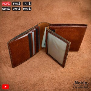 May include: Open brown leather wallet with multiple card slots and a clear ID window. The wallet is displayed open, revealing the interior and a few bills. The wallet is handmade and has a stitched border.