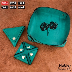 May include: A teal leather tray with a black monstera leaf design, accompanied by two teal leather coin purses with silver snap closures. The tray and purses are displayed on a brown surface. The image also includes file type icons and the text "Noble Leather Art."