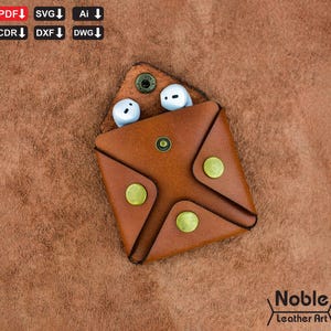 May include: A brown leather earbud case with brass rivets and a snap closure. Two white earbuds are visible inside. The case has a square shape with a folded design. The logo "Noble Leather Art" is in the bottom right corner.