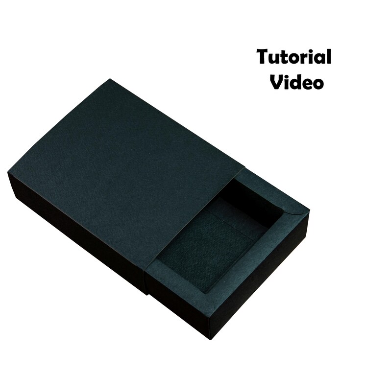 May include: A black, textured, rectangular box with a sliding lid, partially open to reveal a dark interior. The text "Tutorial Video" is displayed in bold, black font.